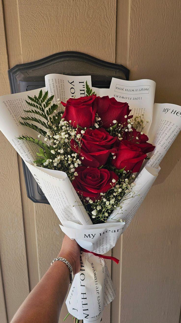 Rosewood Elegance crimson roses in spotted ivory paper with foliage